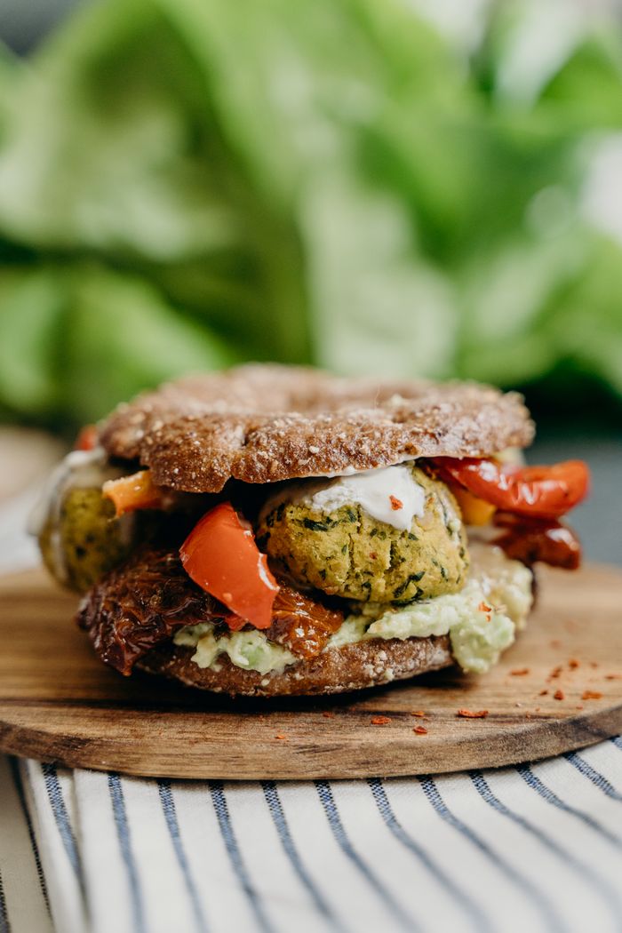 Offerings Close-up of a mouthwatering falafel sandwich with fresh vegetables and spices on rye bread.