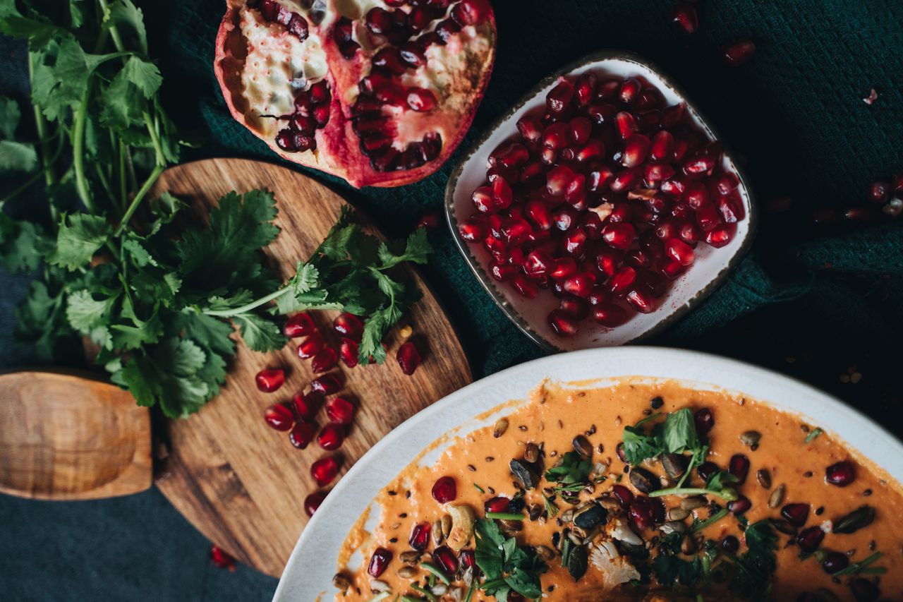 Home Delicious vegan dish garnished with pomegranate and fresh cilantro, perfect for fall dining.