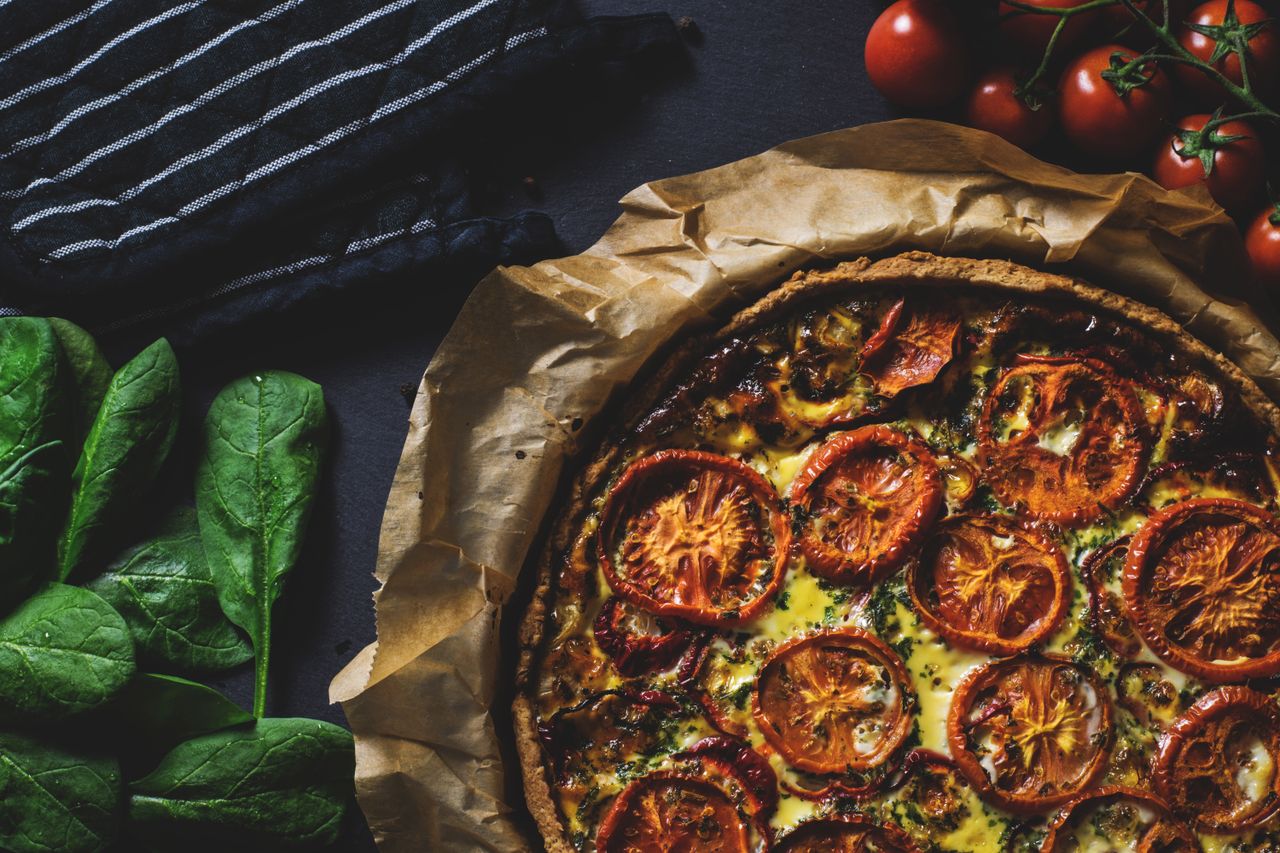 Home Delicious rustic quiche topped with tomatoes, ideal for a healthy and tasty meal.